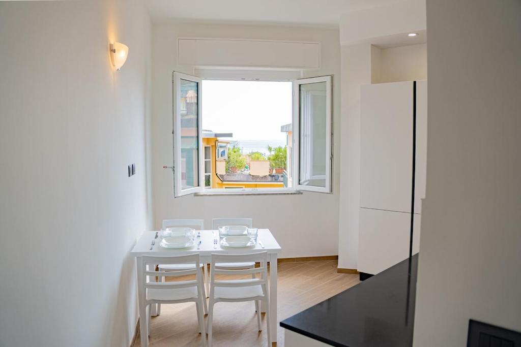 a white table and chairs in a room with a window at Noli Blue Bay in Noli