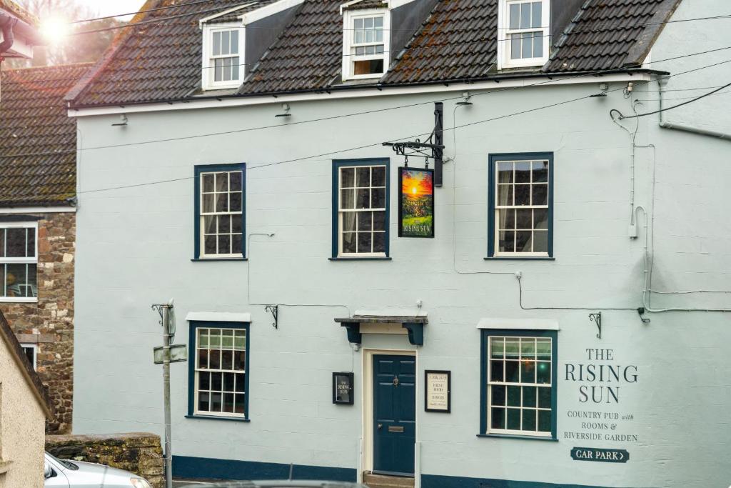 a white building with a sign on it at The Rising Sun - Pensford in Pensford