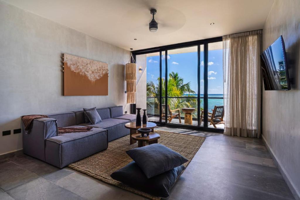 a living room with a couch and a view of the ocean at Luxury Beachfront 4BR PH in Bahia Soliman in Balcheil