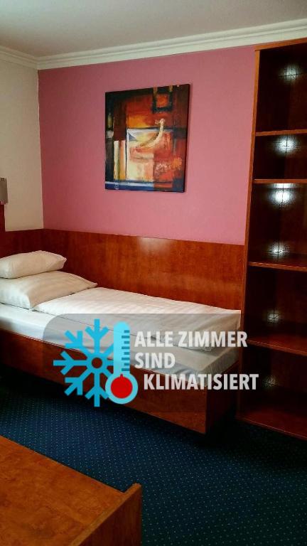 a bedroom with a bed with a pink wall at Atlanta Budget Darmstadt in Darmstadt