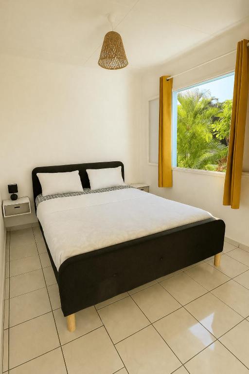 a bedroom with a large bed with a window at Chambres chez l'habitant in Saint-Paul