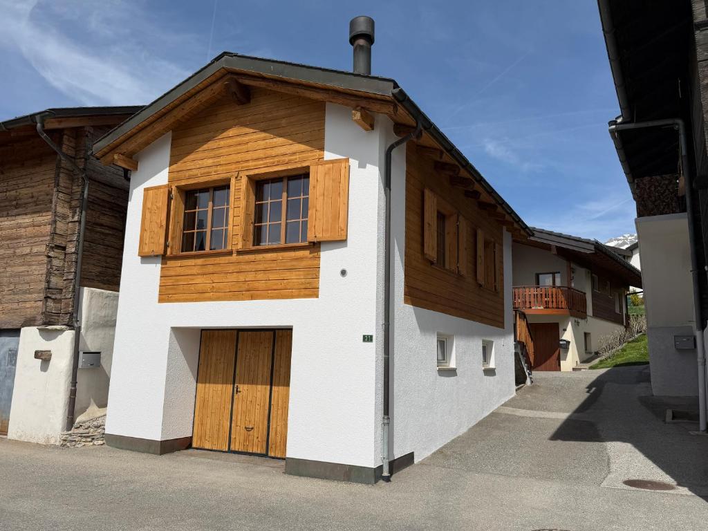 a house with a garage with a wooden door at Le mazot in Lens