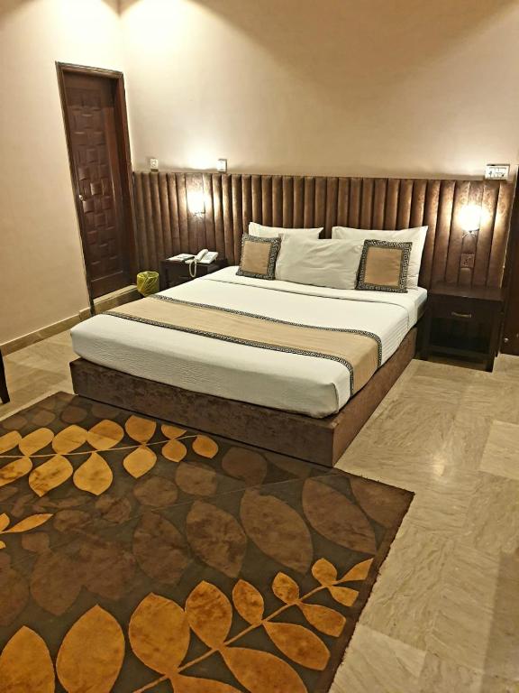 a bedroom with a large bed in a room at Shelton Hotel Johar Town Lahore in Lahore