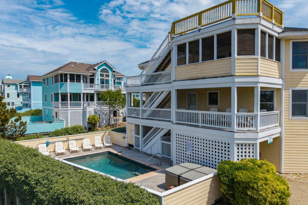a house with a swimming pool in front of it at Heron Landing in Corolla