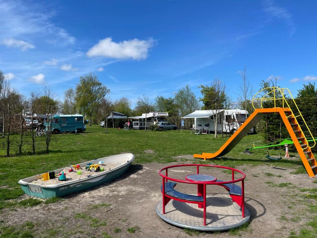 a playground with a boat and a slide at Camping de Boerenzwaluw in Zijdewind