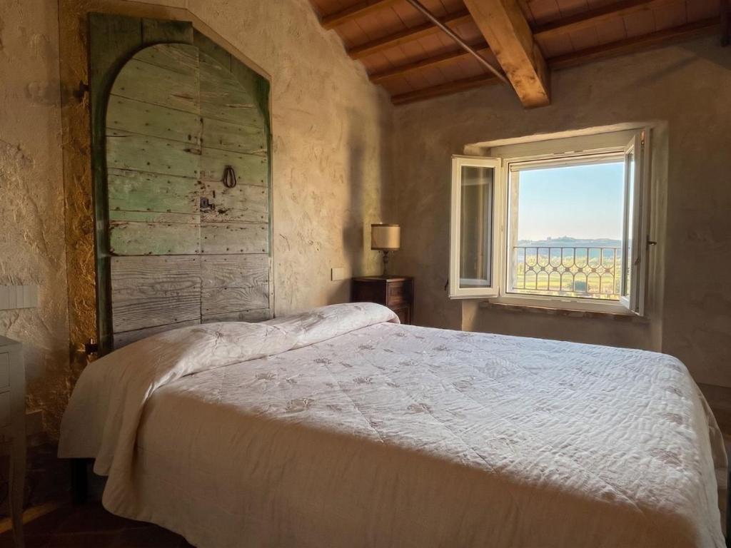 a bedroom with a large bed and a window at La chesa de Prit in Verucchio