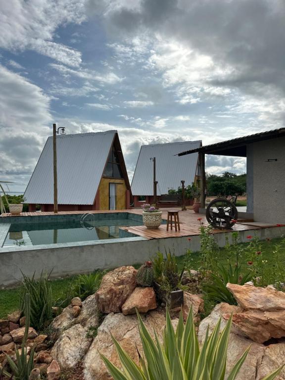 a house with a swimming pool next to a building at Chalé Pontal da Juacema in Ilha Cachoeira