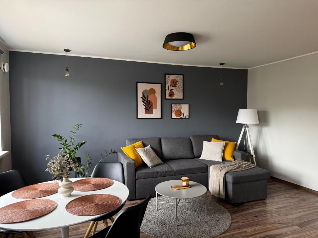 a living room with a couch and a table at Karusselli beach home, free parking in Pärnu