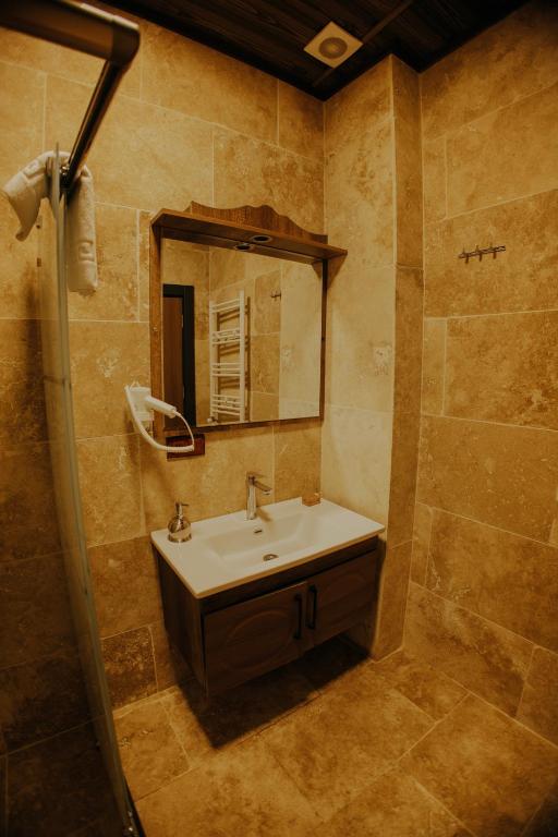 a bathroom with a sink and a mirror at Konak Stone House in Ürgüp