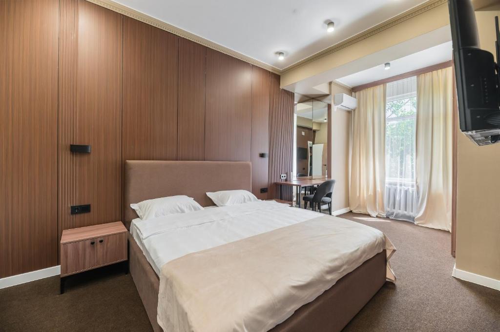 a bedroom with a large bed and a television at UIDE Apart hotel in Almaty