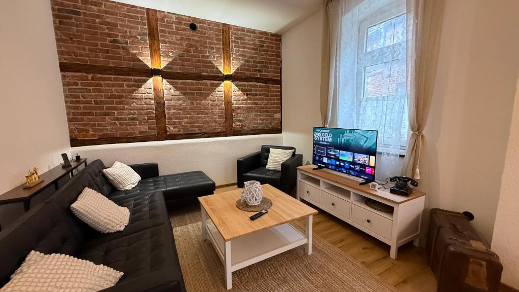 a living room with a black couch and a television at Ferienhaus Anna in Winsen