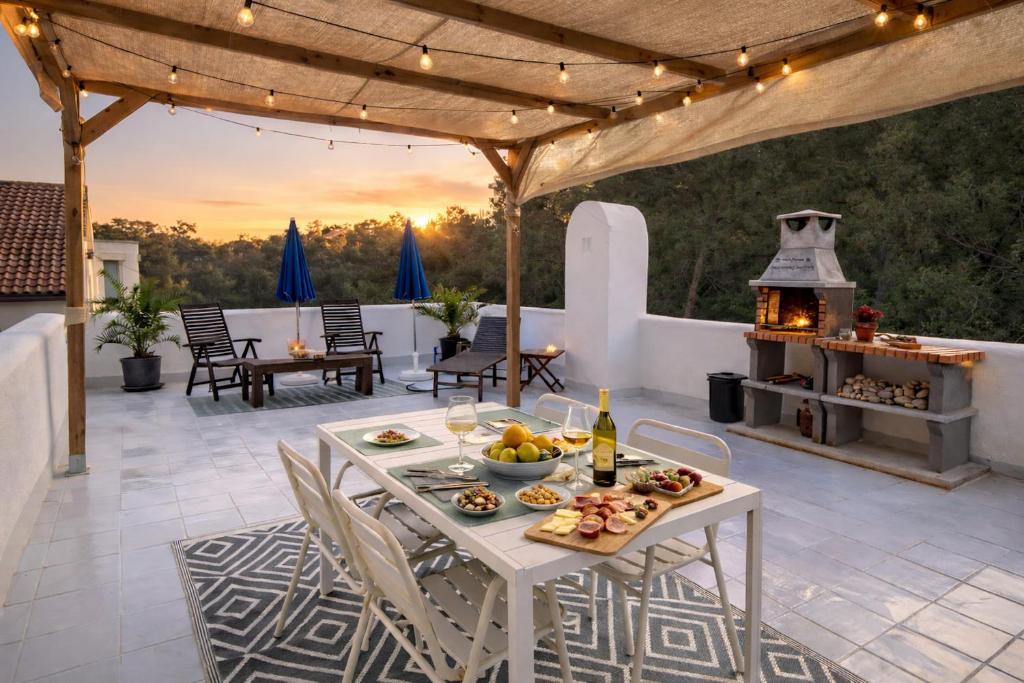 a patio with a table with food and a fireplace at Hauzify I Casa Olivella B in Olivella