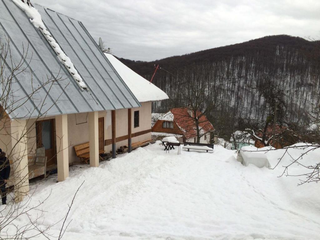 ein Haus mit Schnee auf dem Boden davor in der Unterkunft У Сергія in Lumshory