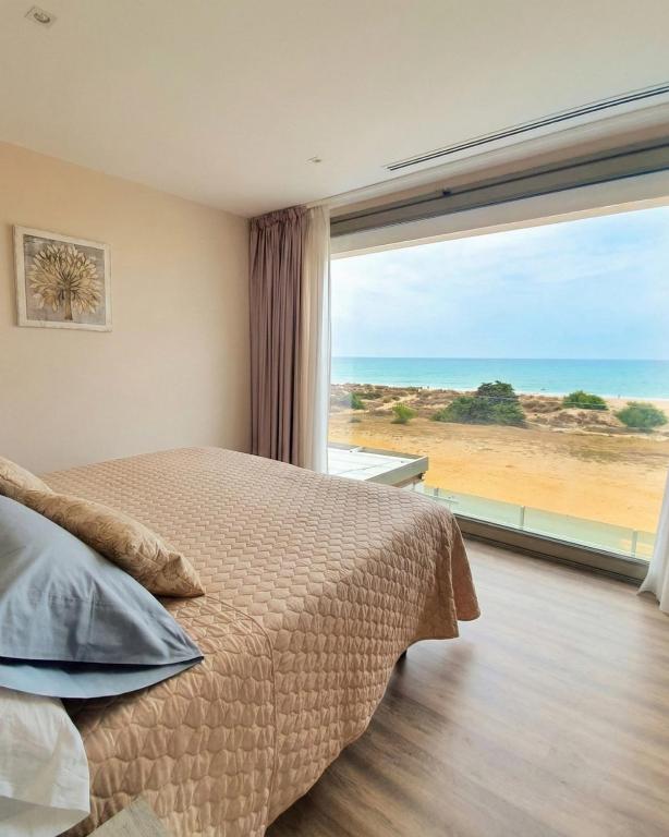 a bedroom with a bed and a large window at Hotel Boutique Aroma de Mar in Chiclana de la Frontera