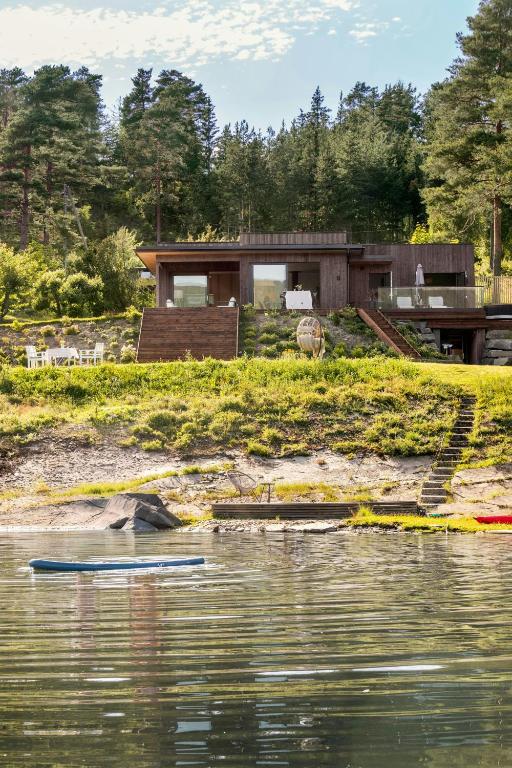 a house on the shore of a body of water at Modern Cabin With Panoramic Views in Hønefoss