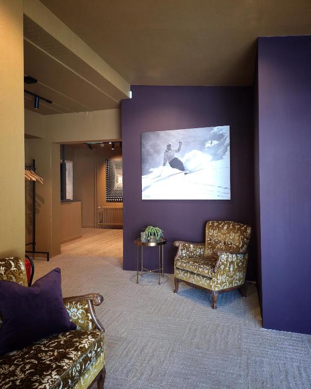 a living room with two chairs and a large screen at Bringenatten Hotell Nesbyen in Nesbyen