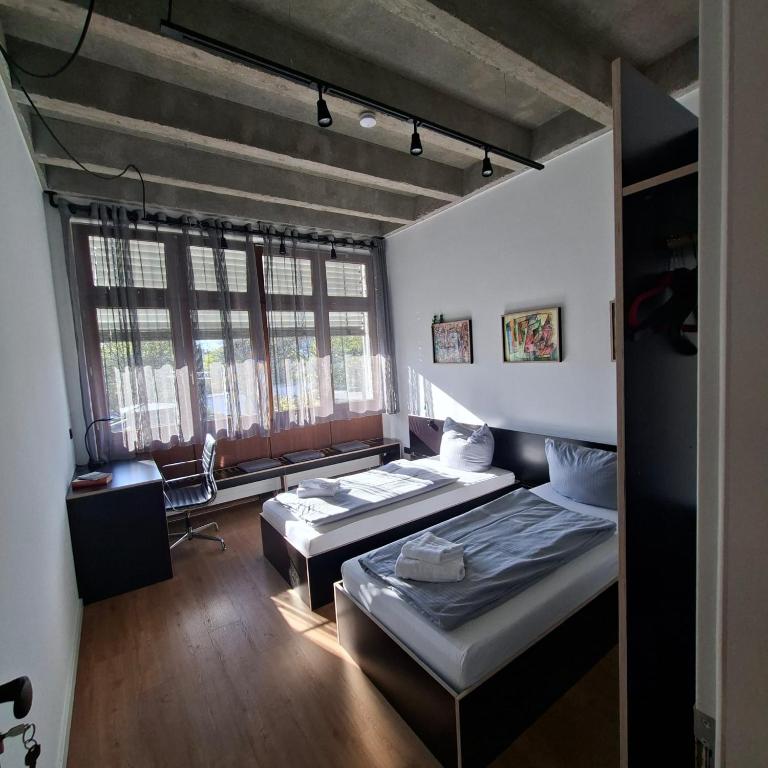 a room with two beds and a window at Estelada Studios Unterhaching in Unterhaching