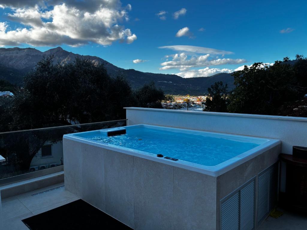 a hot tub on a balcony with a view of mountains at Karen's Favorite in Skala Potamias