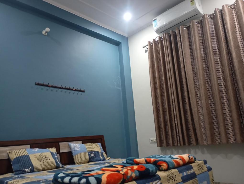 a bedroom with a bed and a large window at DEV PALACE Hotel & Hostel in Palāi