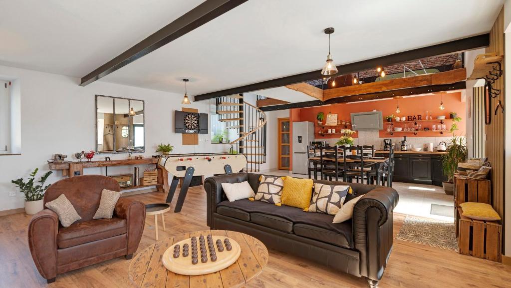 a living room with two couches and a kitchen at Gîte Les Légendes du Plessis in Iffendic