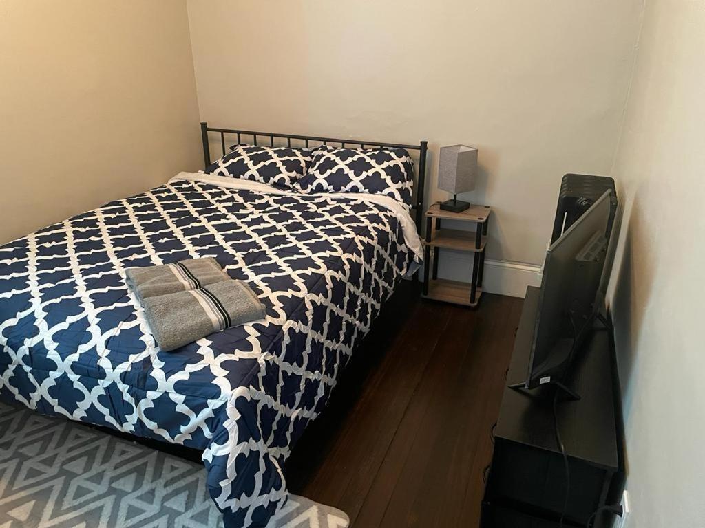 a bedroom with a bed with a blue and white comforter at Homestay in Boston Fields Corner Area in Boston