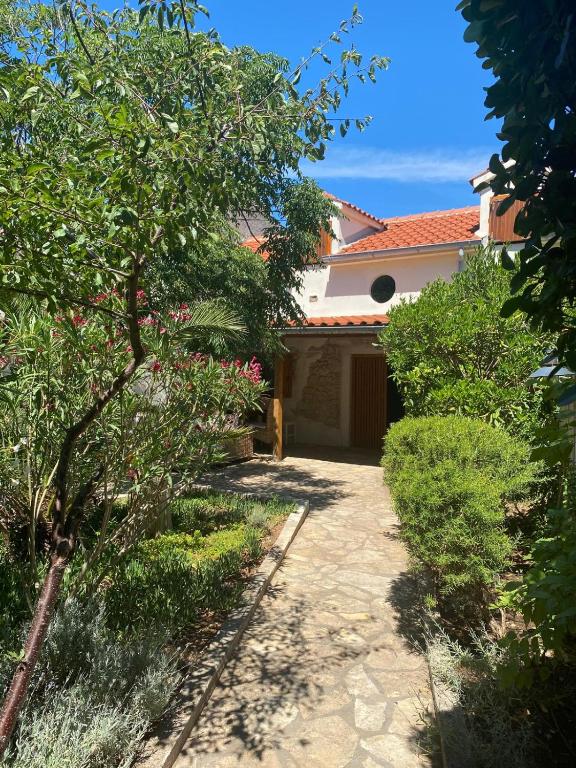 a driveway leading to a house with a garage at Artisana Silba in Silba