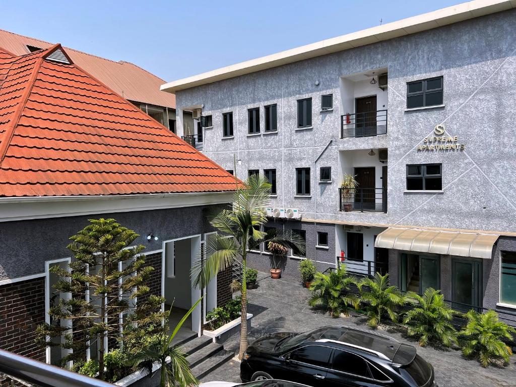an apartment building with a car parked in a parking lot at Supreme Apartments in Ibadan