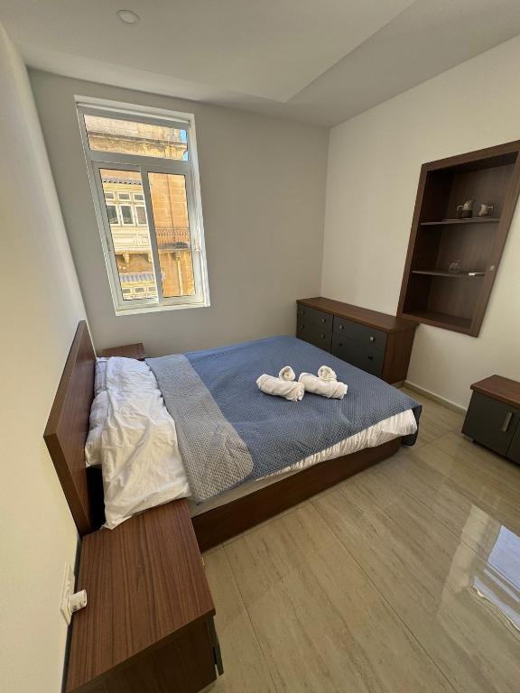 a bedroom with a bed with two towels on it at Valletta Waterfront Hideaway in Il-Furjana