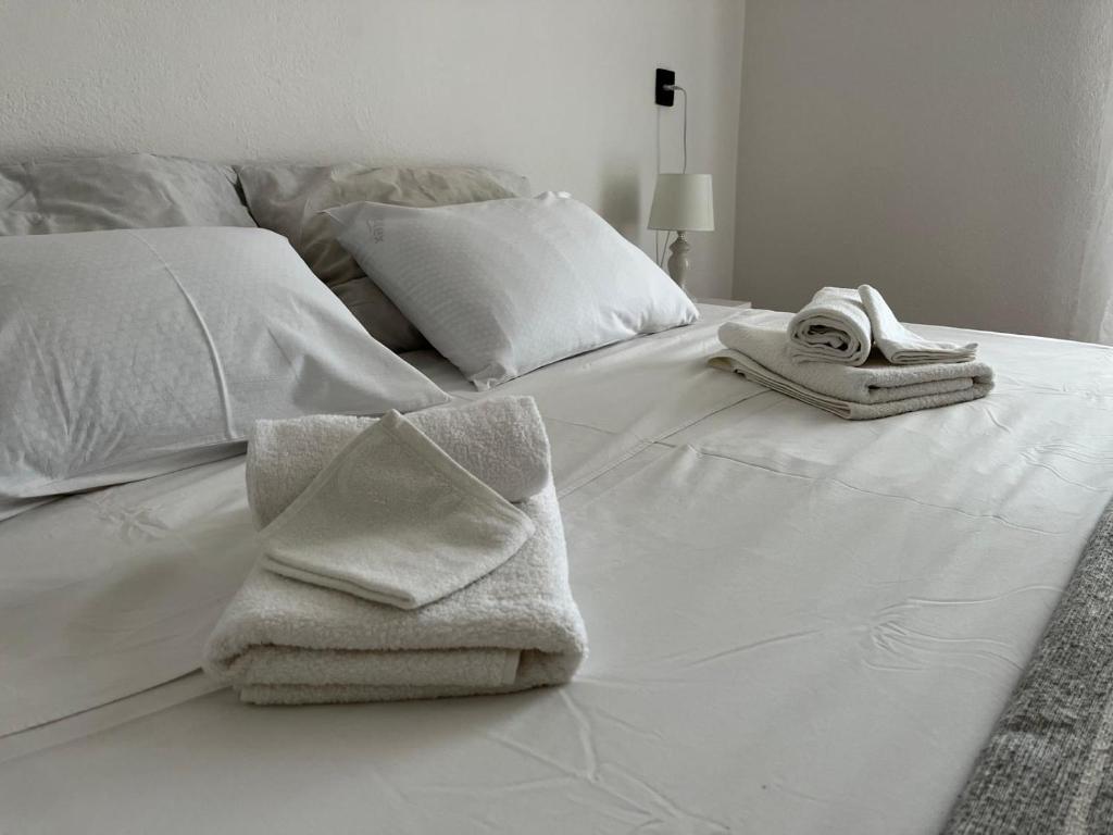 a white bed with towels and pillows on it at Donna Seahouse in Jadranovo