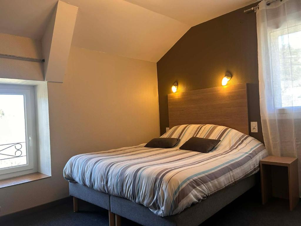 a bedroom with a bed with two pillows on it at Logis Hôtel Restaurant Les Cévennes in Saint-Cirgues-en-Montagne