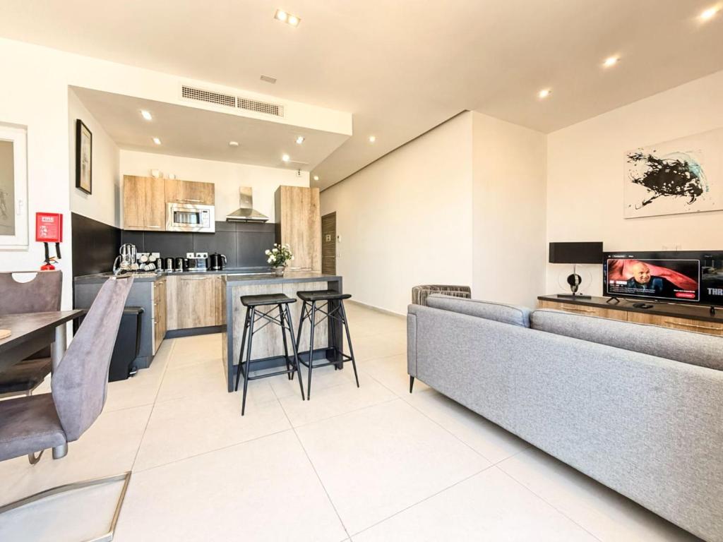 a kitchen and living room with a couch and a bar at St Julians - Spinola Space by DNA in St. Julianʼs