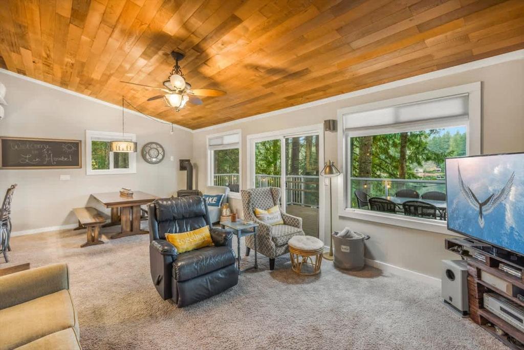 a living room with a couch and a tv at Lakefront retreat with view deck & private dock in Shelton