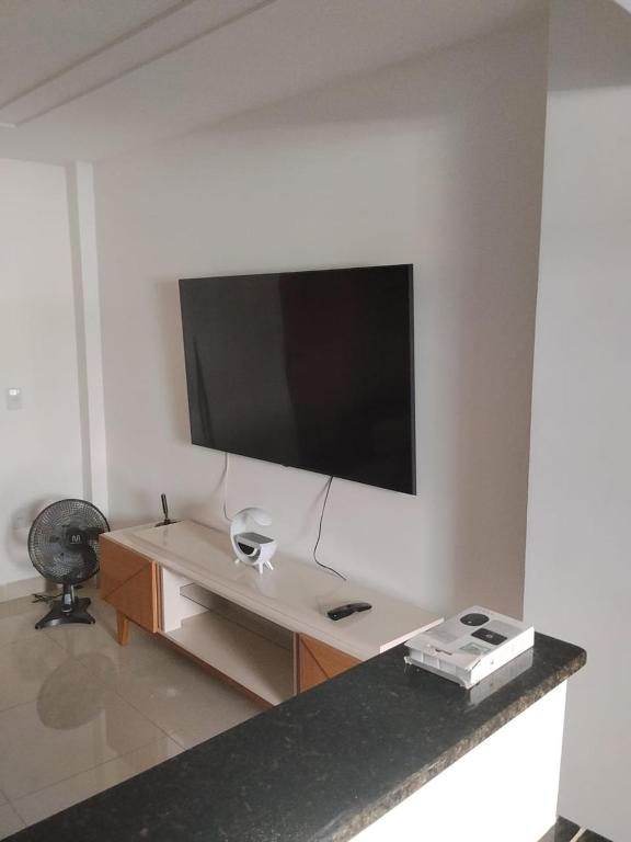 a living room with a television on a wall at Apê Boa Vista in Vila Velha