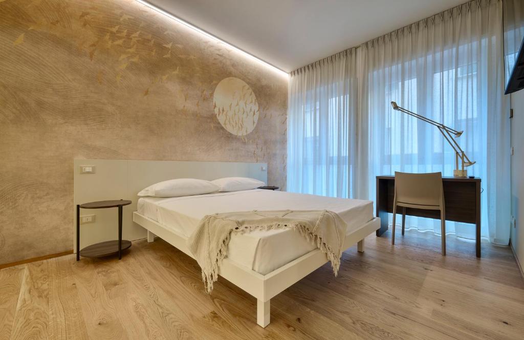 a bedroom with a white bed and a desk at Elegante appartamento - centro Lecco in Lecco