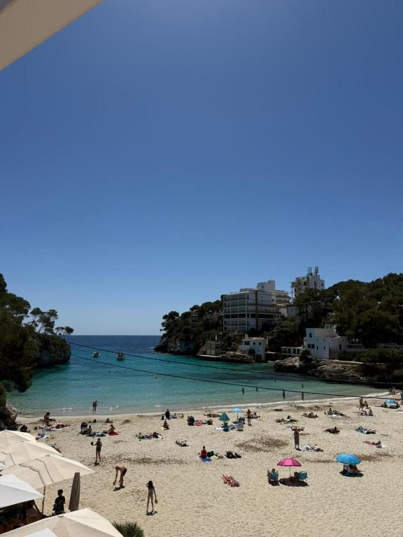 a group of people on a beach with the ocean at Hostal Playa in Cala Santanyi