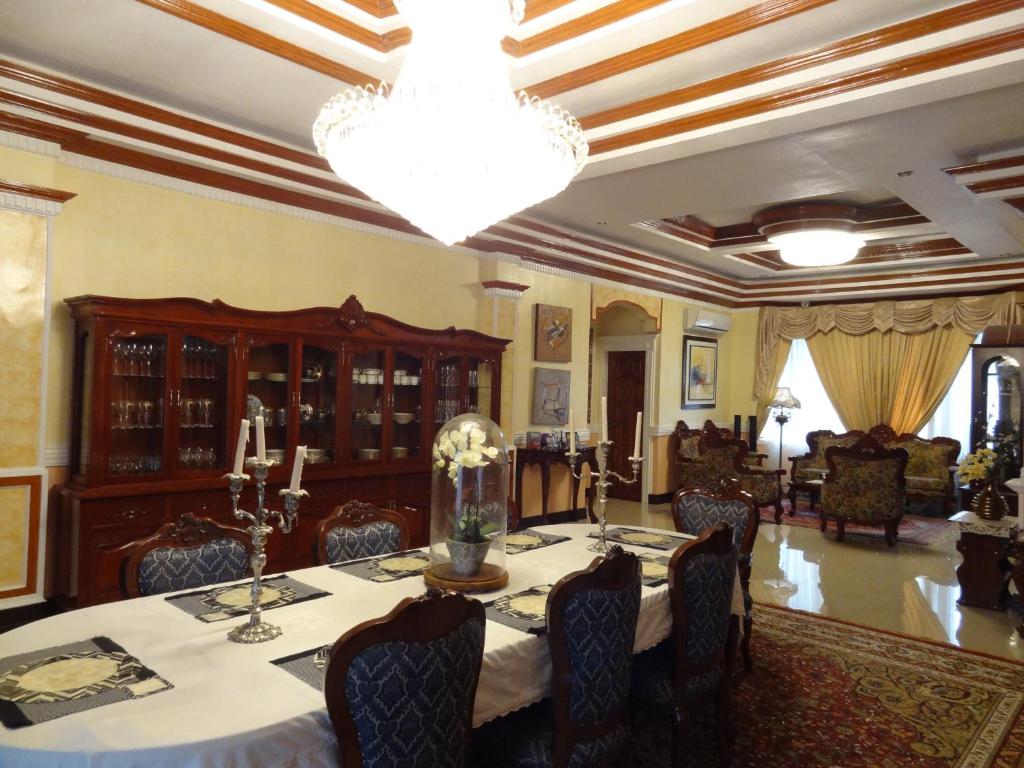 una sala da pranzo con tavolo e lampadario pendente di The Executive Villa Inn & Suites a Davao