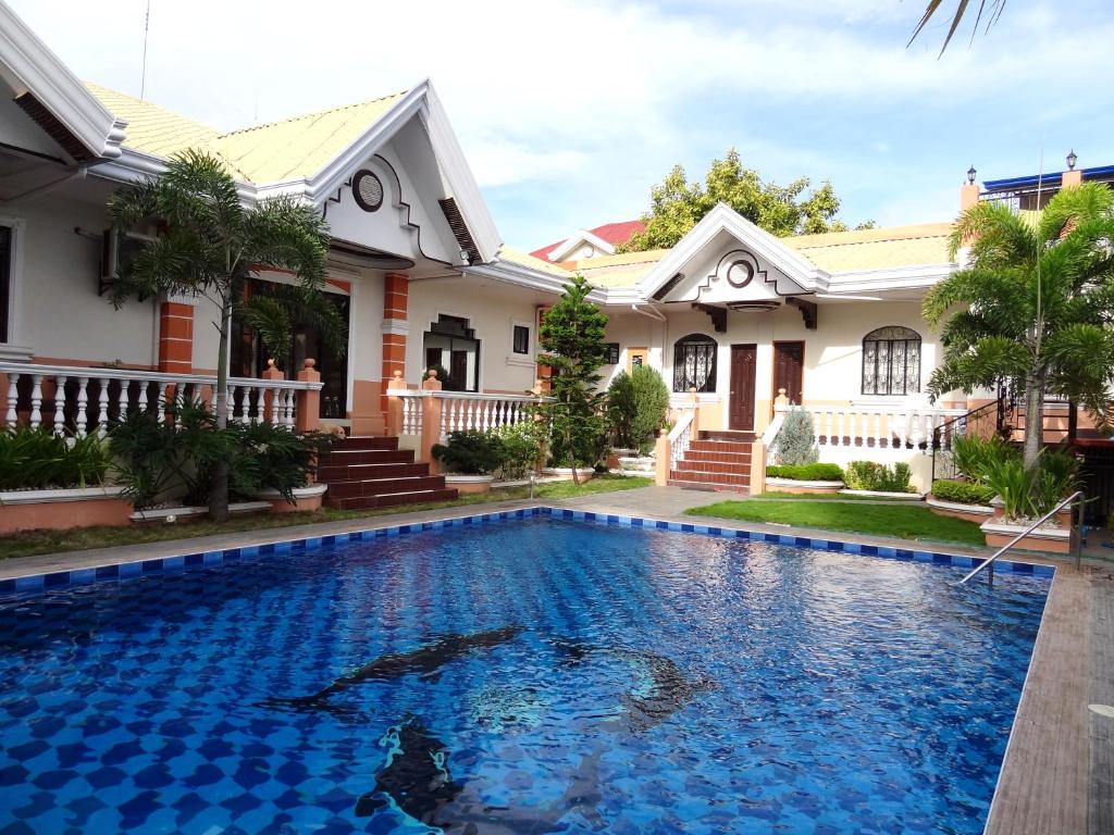 a house with a swimming pool in front of a house at The Executive Villa Inn & Suites in Davao City