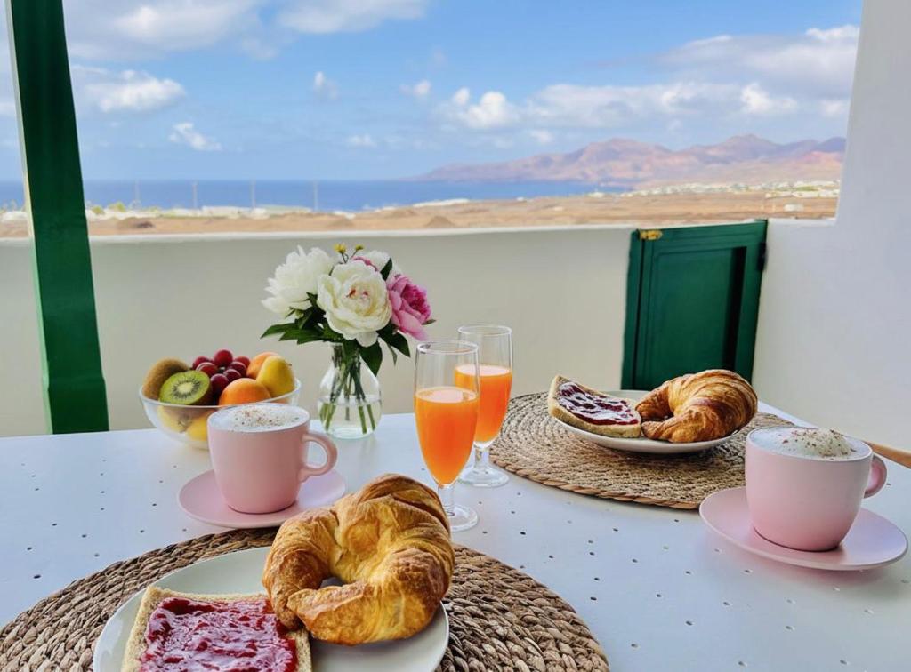 a table with pastries and drinks and a table with a view at Vista Paraiso in Tías