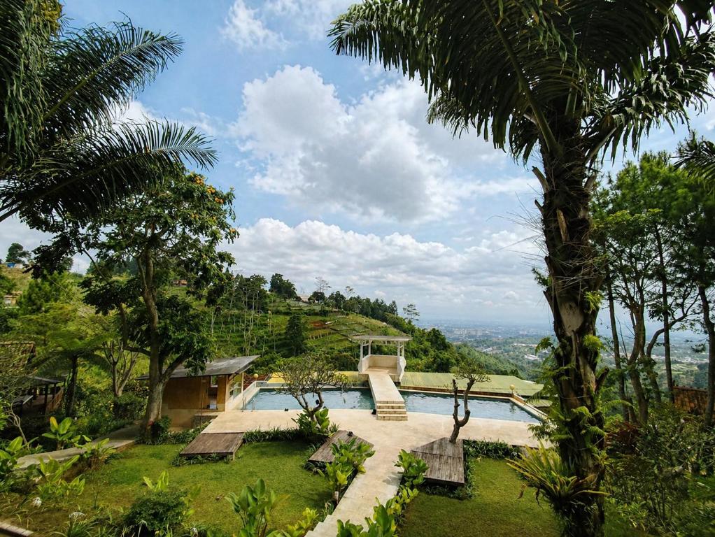 a resort with a pool and palm trees at Dulang Resort & Resto in Bongkar 2