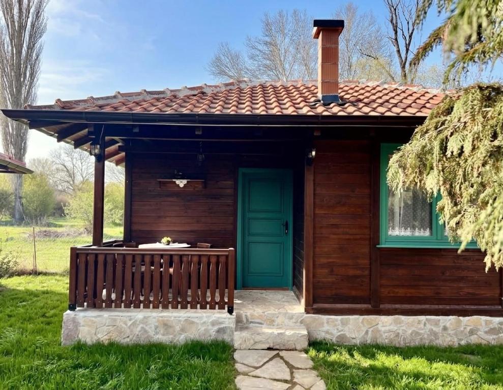 a small house with a green door and a porch at Selsko domacinstvo Nevena in Kumanovo