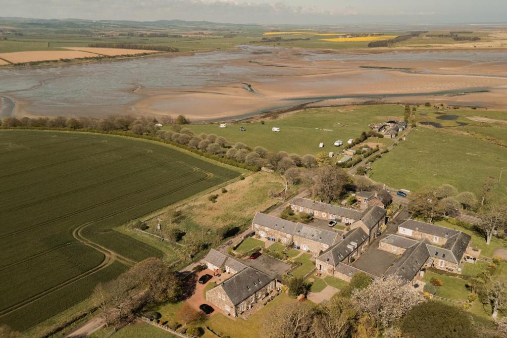 an aerial view of a house and a field at Puffin Cottage, Bamburgh in Bamburgh