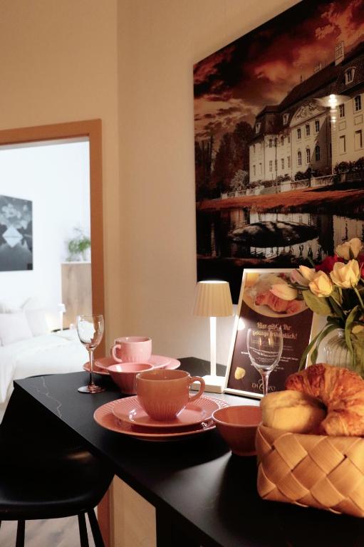 ein Raum mit einem Tisch mit Tellern und Weingläsern in der Unterkunft Altmarktstudio1 in Cottbus