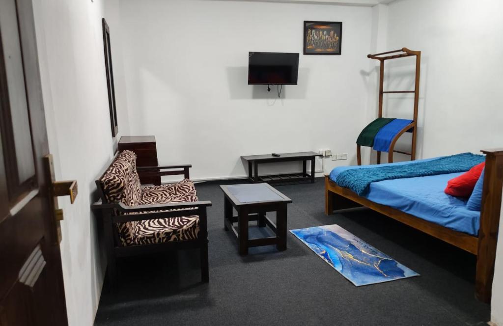 a bedroom with a bed and a chair and a desk at Sri VK Residency - Buget Friendly Colombo Hotel in Colombo