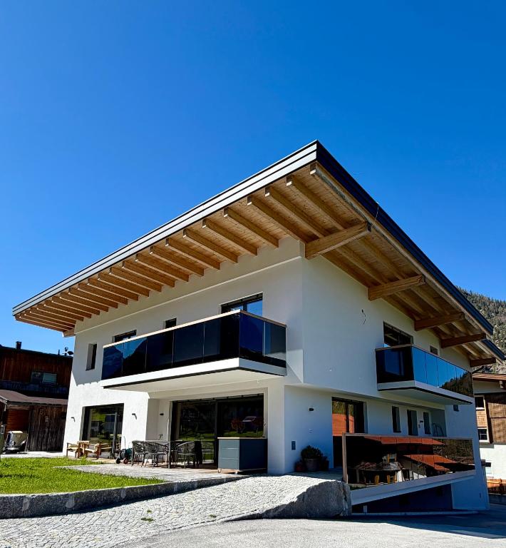 a large white house with a roof at MALIA - Alpine Hideaway in Pertisau