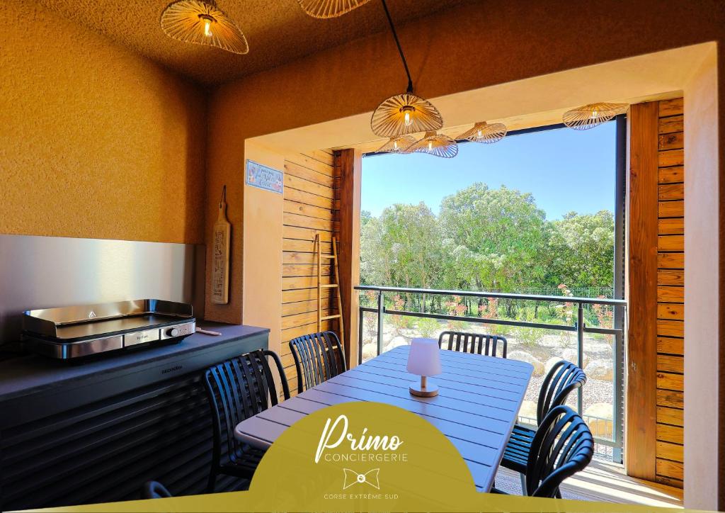 a dining room with a blue table and a balcony at KerTerra Corsica - Apt 3 chambres - Piscine & plage privée in Pianottoli-Caldarello