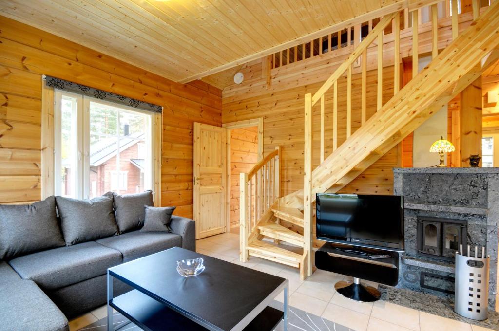 a living room with a couch and a fireplace at Puttitie 4B in Tahkovuori
