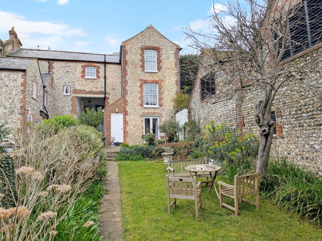 a garden with a table and chairs in front of a building at Gainsford - Arundel in Arundel