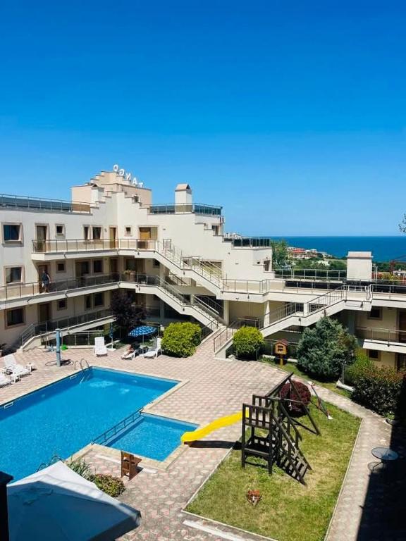 a large building with a swimming pool next to the ocean at Apartment Sommer-Tango in Byala