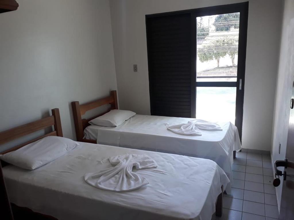 drei Betten in einem Zimmer mit Fenster in der Unterkunft Passos Inn Hotel in Passos