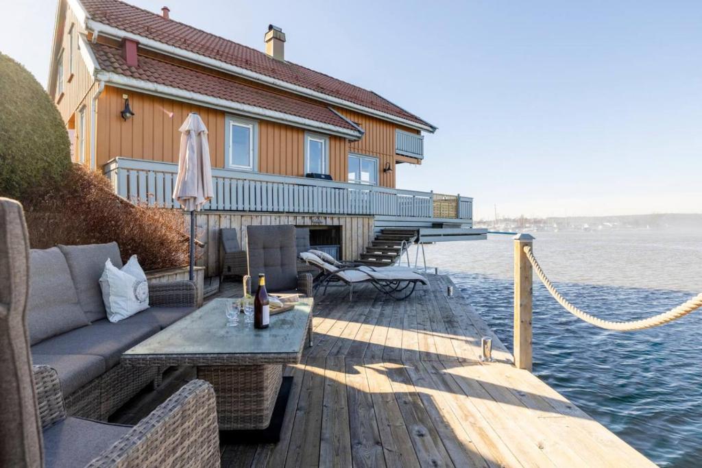 a house on a dock with a couch and an umbrella at Waterfront Home-Tonsberg in Tønsberg
